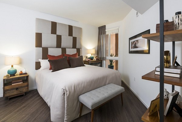 Garey Building Apartments: Modern bedroom with stylish decor and natural lighting