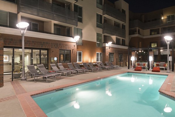 Garey Building Apartments: Relaxing outdoor pool area with lounge chairs and city views, providing luxury amenities for residents