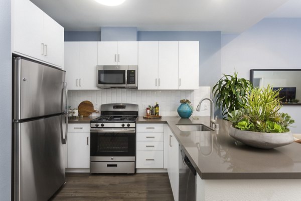 Kitchen with stainless steel appliances and granite countertops in Aspect Apartments