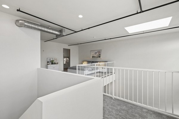 Hallway with exposed brick walls and modern lighting at San Pedro Bank Lofts luxury apartments