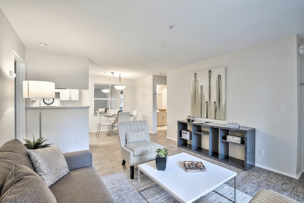 Living room featuring elegant decor and large windows at Alvista at the Bridge Apartments