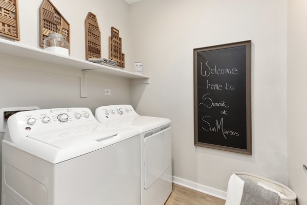 Laundry room featuring modern machines at Summit at San Marcos Apartments