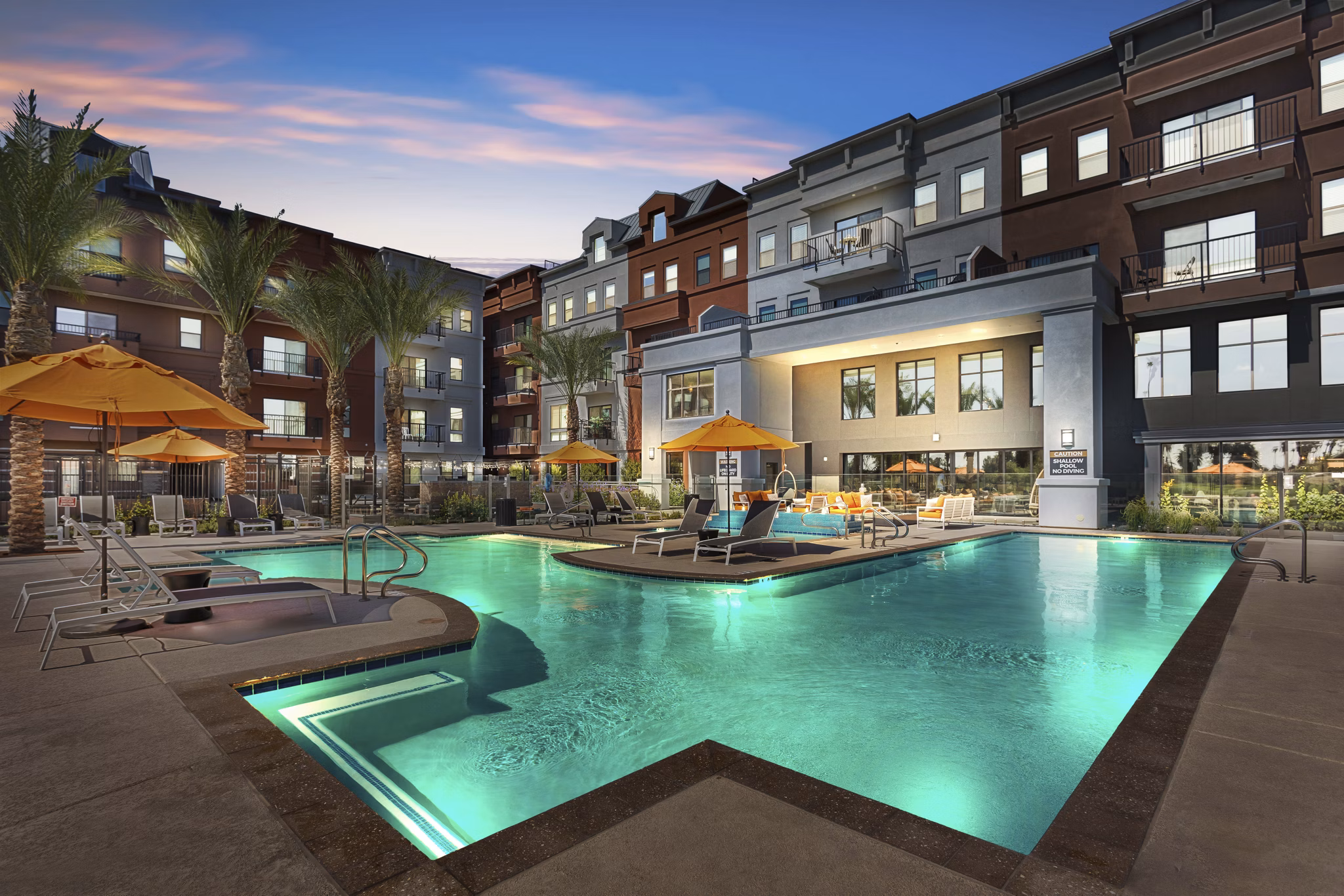 Resort-style swimming pool with lounge chairs at Summit at San Marcos Apartments