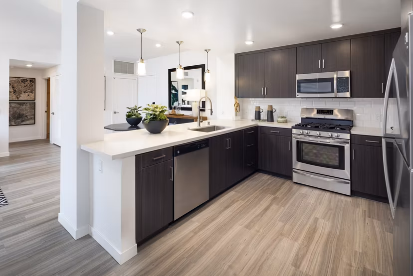 Modern kitchen featuring granite countertops and stainless steel appliances at Boardwalk at Millenia Apartments