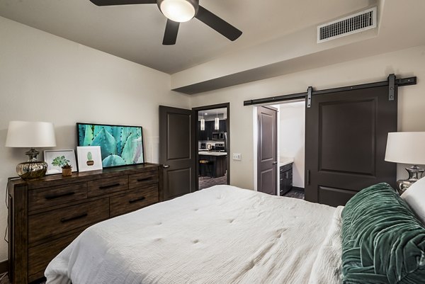 Cozy bedroom with contemporary decor at Peak 16 Apartments, showcasing modern luxury living in a prime location