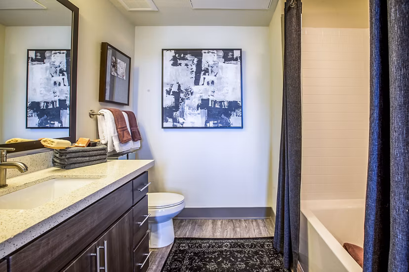 Bright bathroom with sleek fixtures and large mirror at Peak 16 Apartments, offering modern luxury living spaces