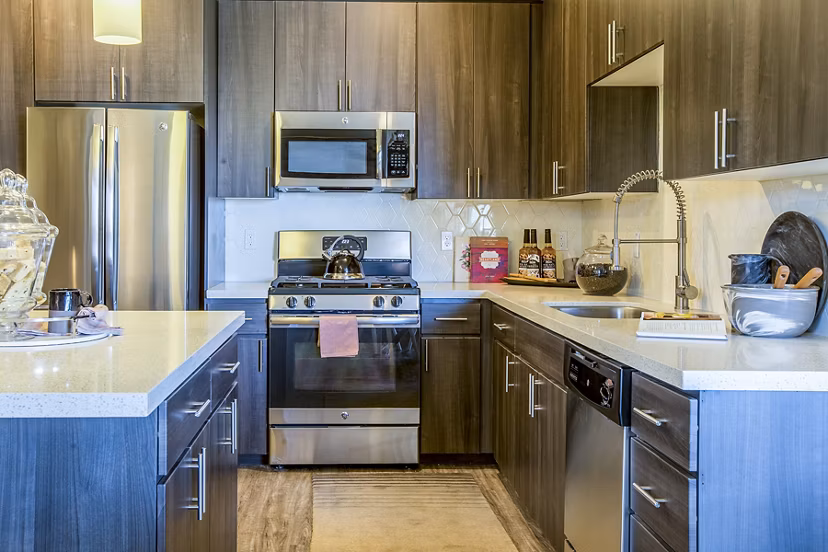 Modern kitchen with stainless steel appliances and granite countertops at Peak 16 Apartments