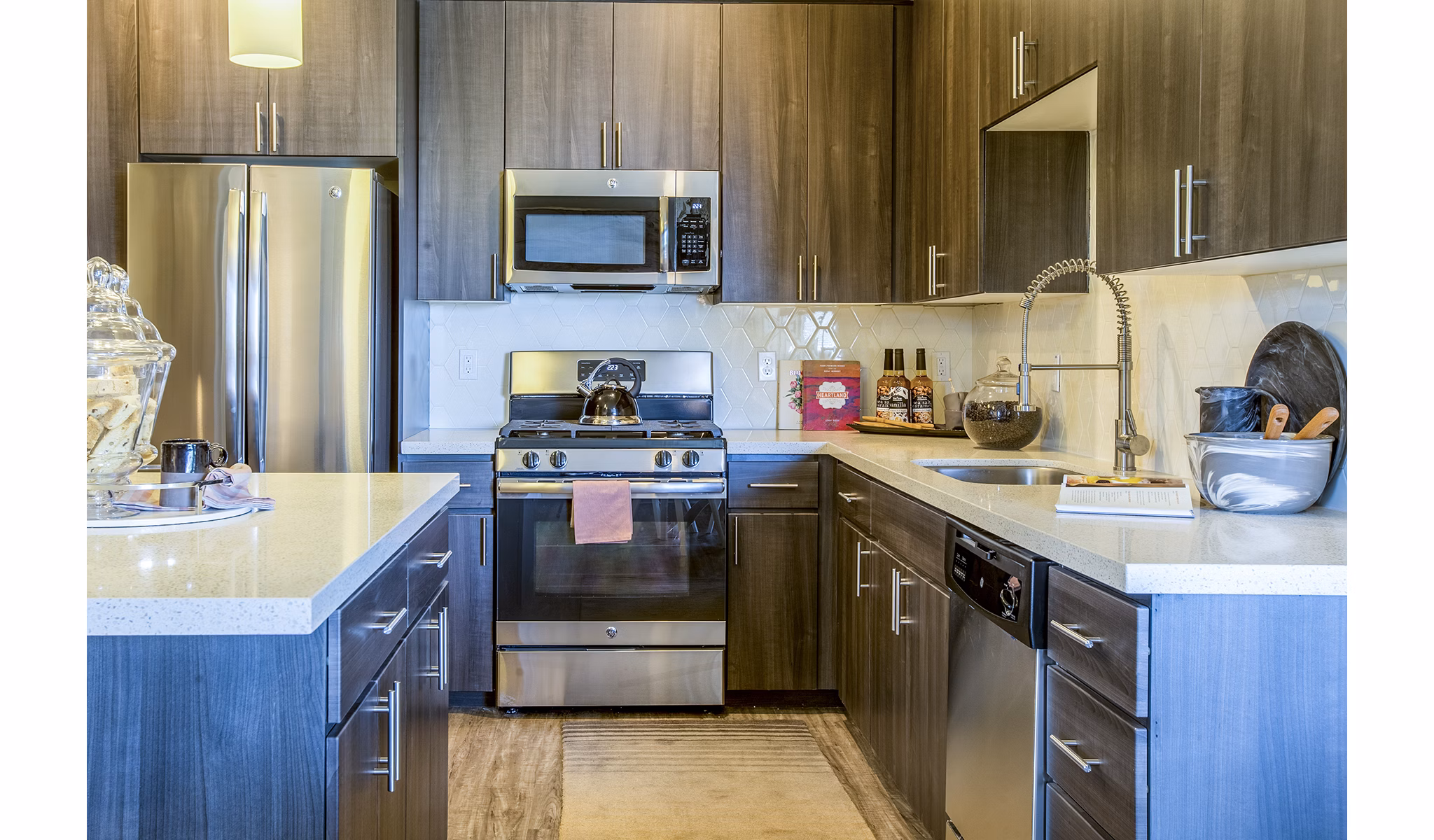 Modern kitchen with stainless steel appliances and granite countertops at Peak 16 Apartments