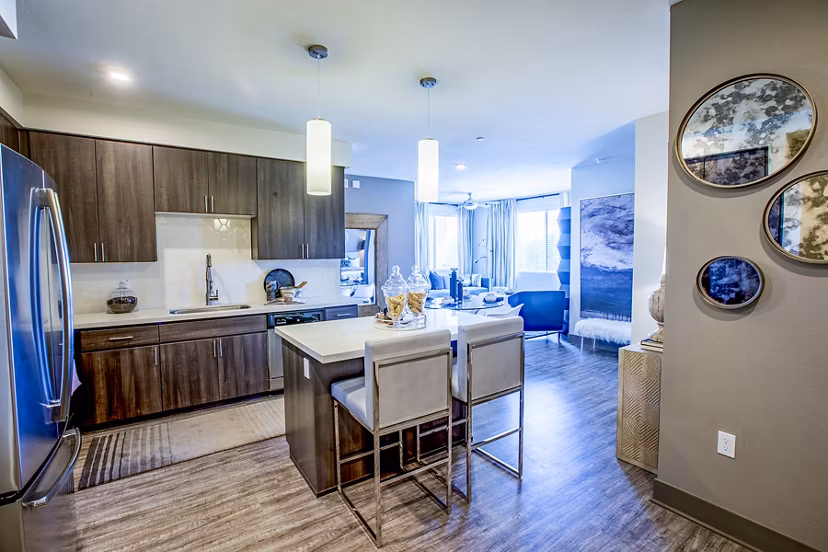 Modern kitchen featuring stainless steel appliances and granite countertops in Peak 16 Apartments, luxury living in a vibrant community