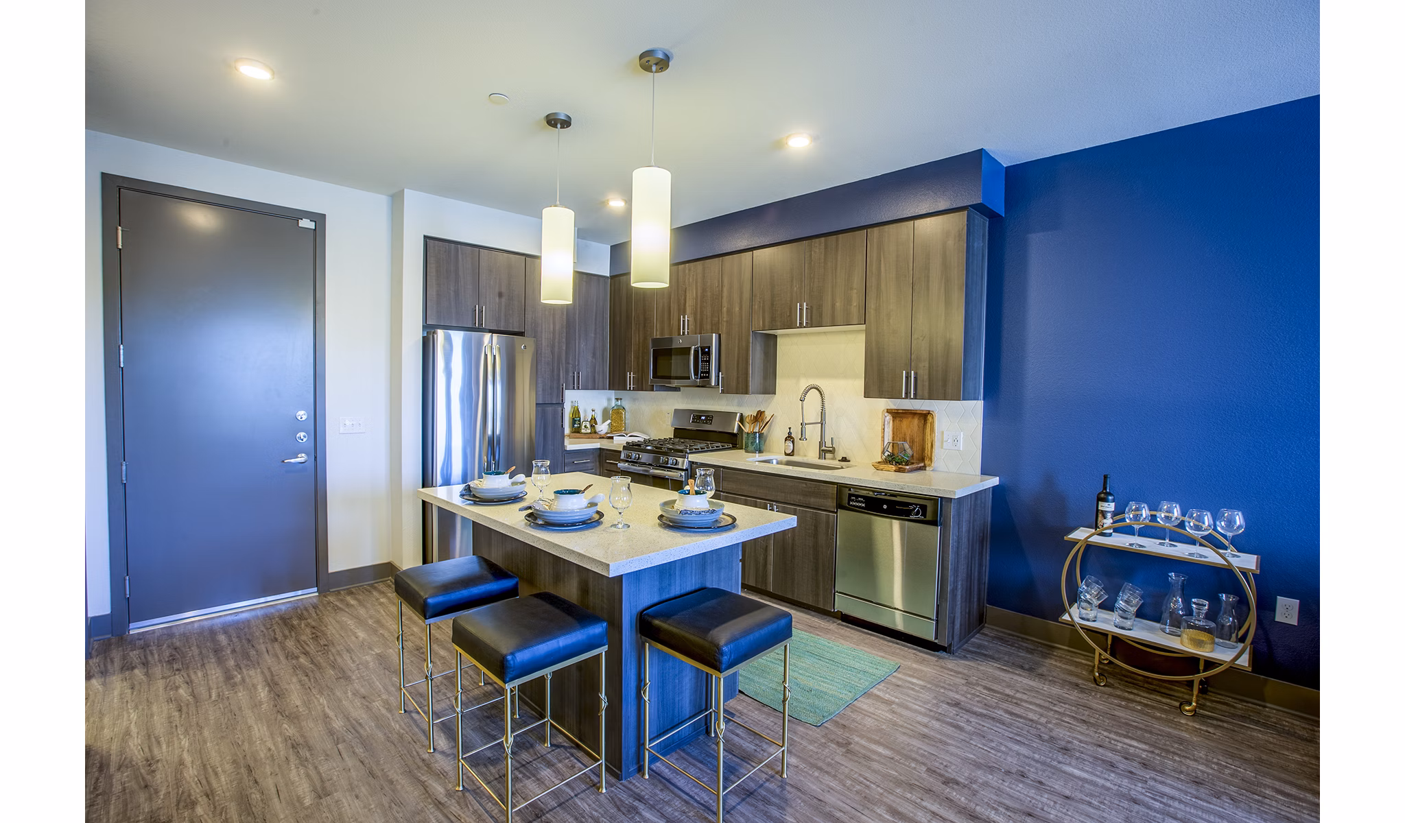 Modern kitchen featuring stainless steel appliances and granite countertops at Peak 16 Apartments