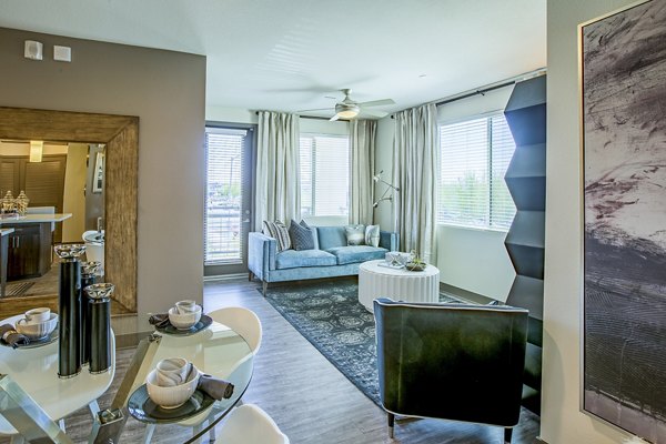 Spacious living room with modern decor and large windows at Peak 16 Apartments, providing a luxury experience in the heart of the city