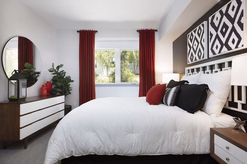Cozy bedroom with modern furnishings and large windows at Vaya Apartments