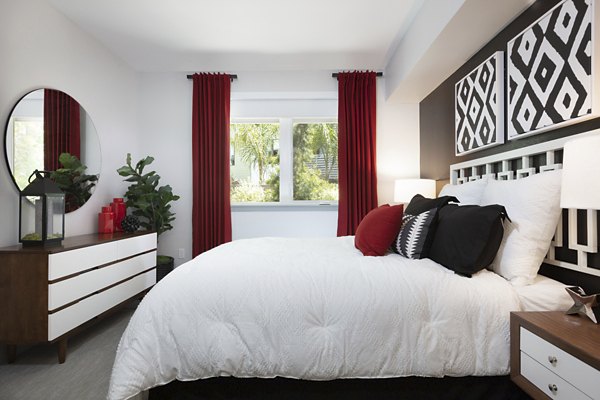 Cozy bedroom with modern furnishings and large windows at Vaya Apartments