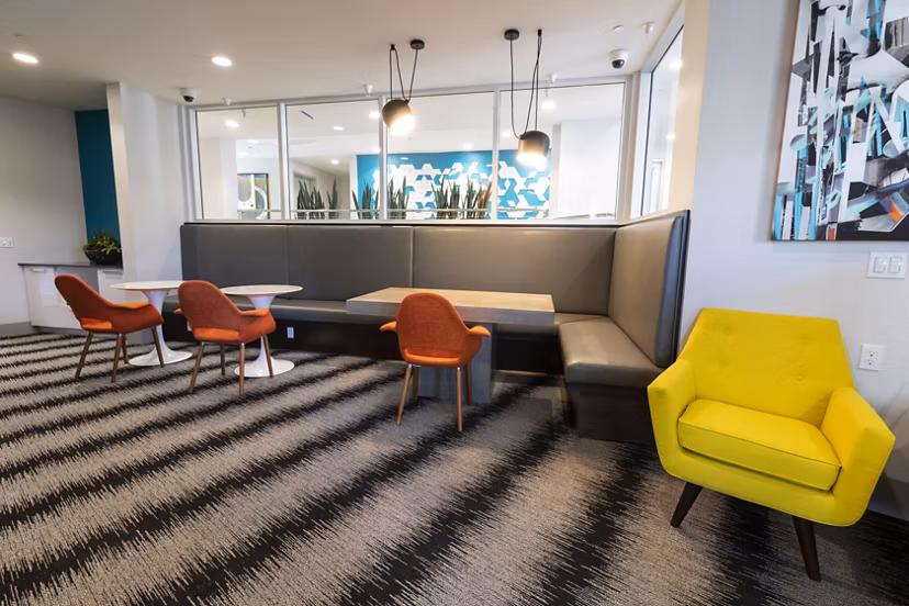 Modern clubhouse with elegant seating and large screen TV at Vaya Apartments, a Greystar luxury community in the heart of the city