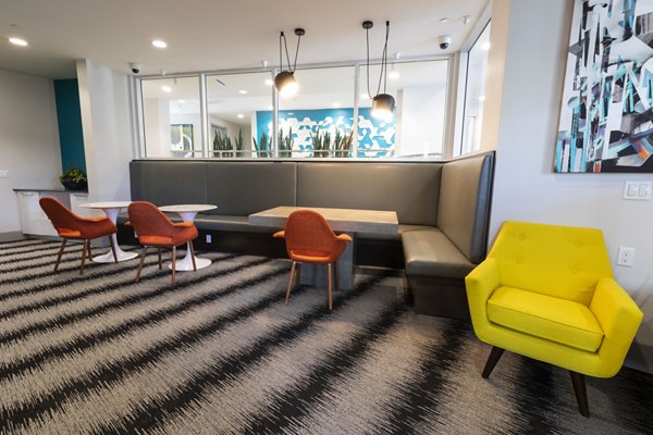 Modern clubhouse with elegant seating and large screen TV at Vaya Apartments, a Greystar luxury community in the heart of the city