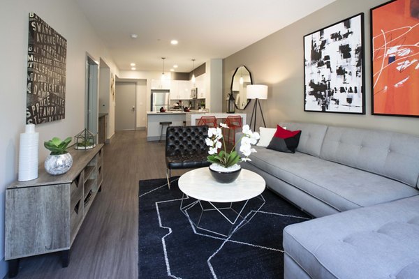 Spacious living room with chic decor and large windows in Vaya Apartments, offering luxury living for Greystar residents