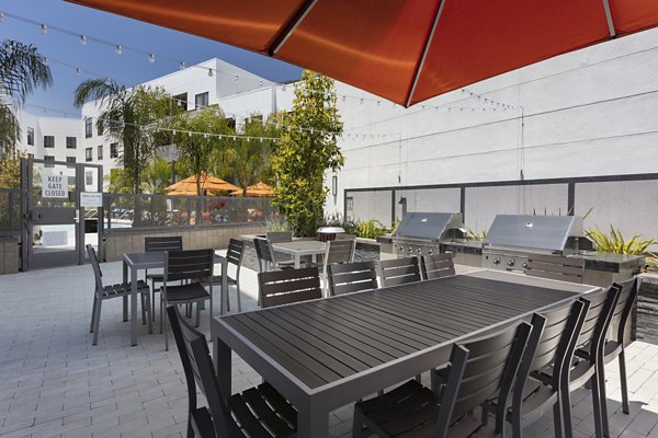 Outdoor grill area with modern seating at Vaya Apartments, a luxury community by Greystar