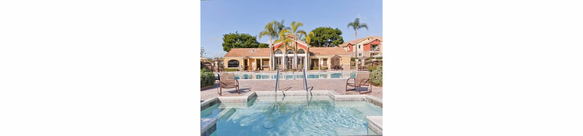 Serene pool oasis at Overlook at Bernardo Heights Apartments with surrounding lounge chairs and lush landscaping, perfect for relaxation