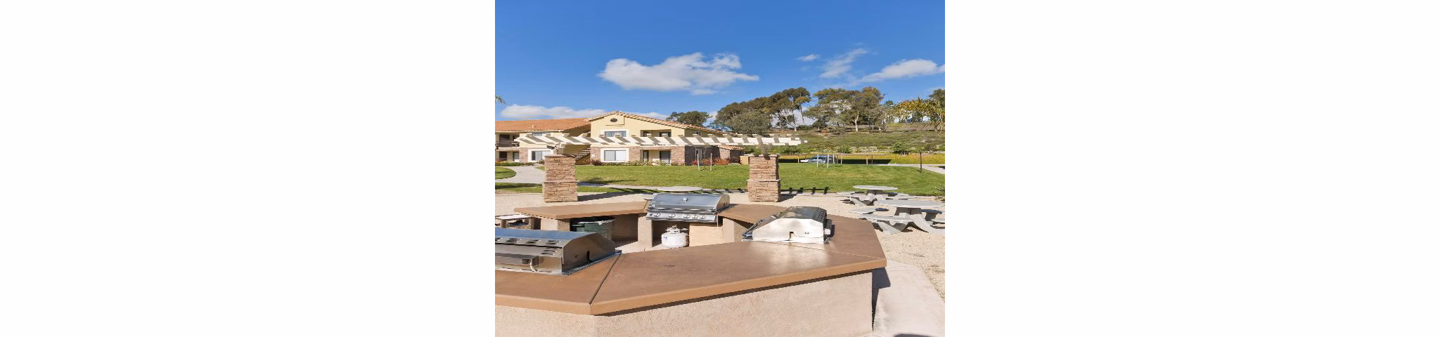 Outdoor grill area with seating at Overlook at Bernardo Heights Apartments, ideal for gatherings and leisure in a scenic environment