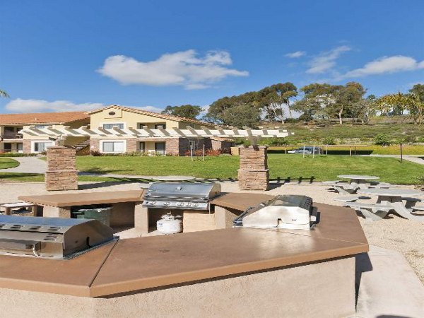 Outdoor grill area with seating at Overlook at Bernardo Heights Apartments, ideal for gatherings and leisure in a scenic environment