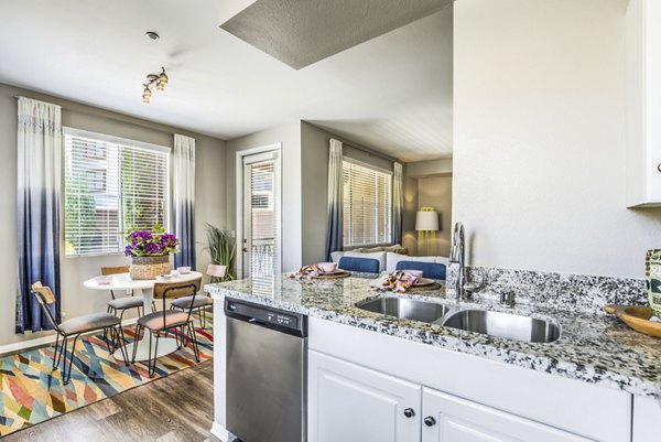 Kitchen with modern appliances and granite countertops in Regents Court Apartments
