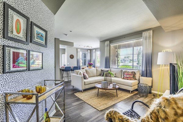 Modern living room with large windows and stylish decor at Regents Court Apartments