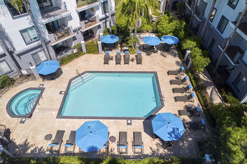 Luxurious pool with surrounding lounge chairs at Regents Court Apartments in a peaceful setting, ideal for relaxation and recreation