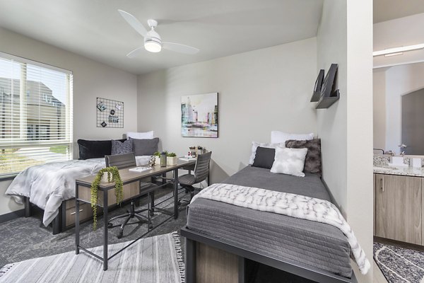 Bedroom with modern furnishings and ample natural light at Hornet Commons Apartments