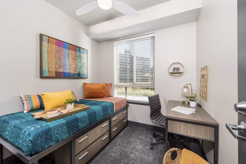 Bedroom with contemporary furnishings at Hornet Commons Apartments, a luxury Greystar property