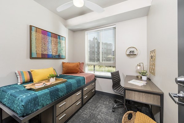 Bedroom with contemporary furnishings at Hornet Commons Apartments, a luxury Greystar property