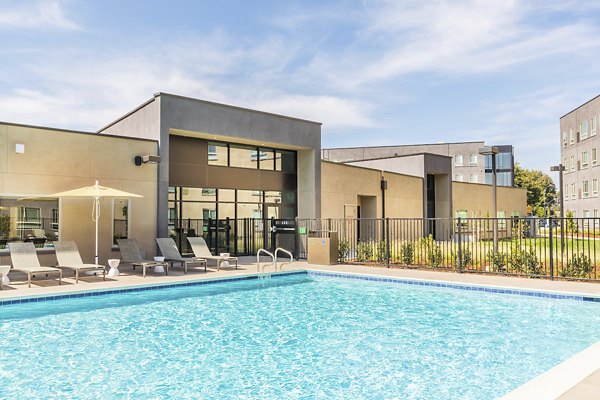 Resort-style swimming pool with lounge chairs at Hornet Commons Apartments, offering relaxation and leisure amenities for residents
