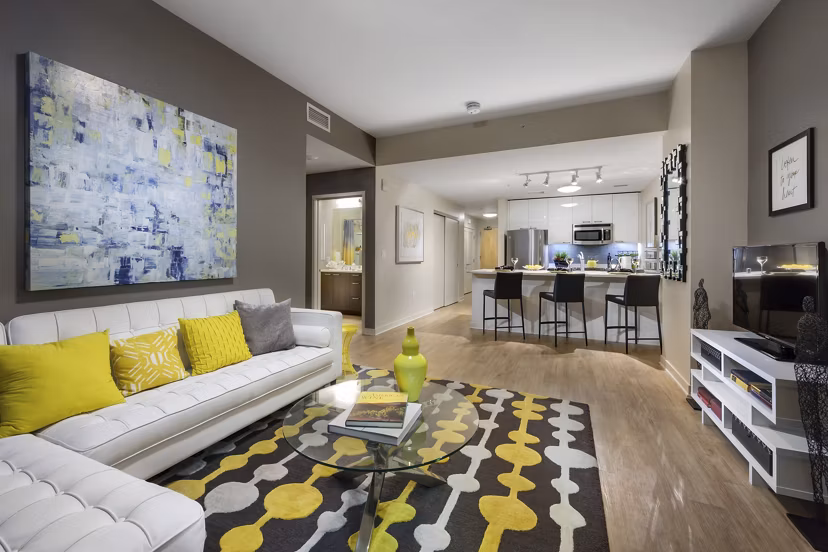 Modern living room with plush seating and large windows at One South Market Apartments