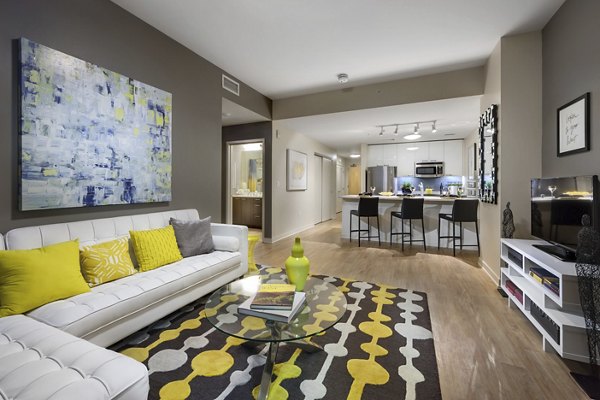 Modern living room with plush seating and large windows at One South Market Apartments