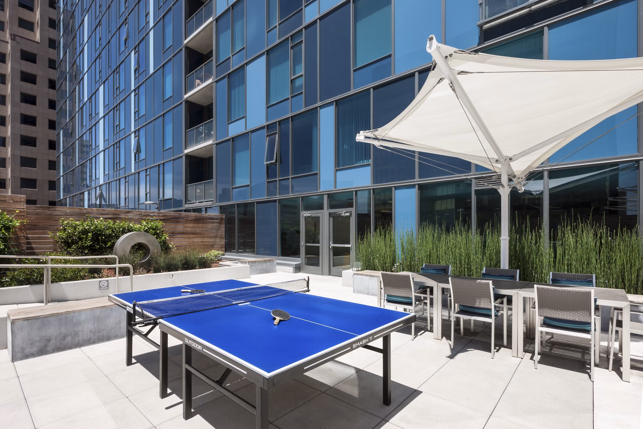 One South Market Apartments: Tranquil courtyard featuring lush greenery and seating areas in San Jose luxury community