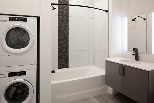 Laundry room and bathroom featuring modern appliances and sleek fixtures at Caldwell Apartments