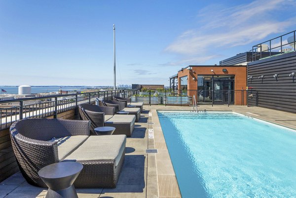 Chic outdoor pool area at Caldwell Apartments featuring comfortable lounge chairs and shaded spaces