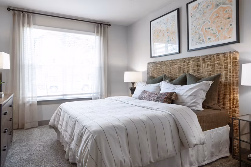 Bedroom with stylish decor and large windows at Broadstone Vintage Park Apartments: A luxury Greystar residence in a tranquil Houston setting