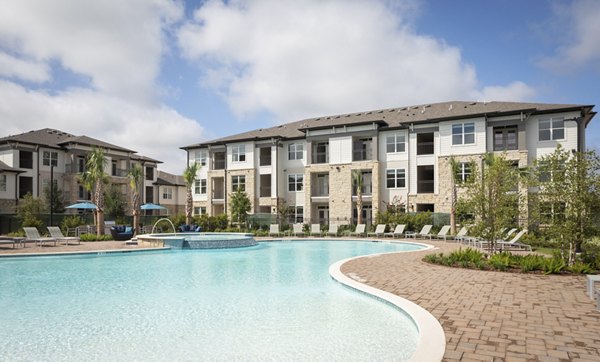 Resort-style pool at Broadstone Vintage Park Apartments, featuring lounge seating and palm trees