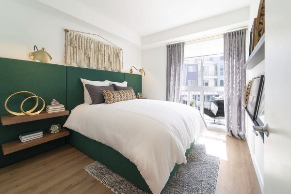 Modern bedroom with large windows at The Upper Ivy Apartments