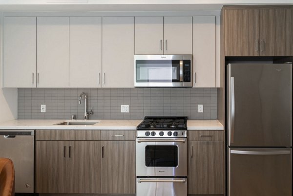 Modern kitchen with sleek cabinetry and granite countertops at The Upper Ivy Apartments