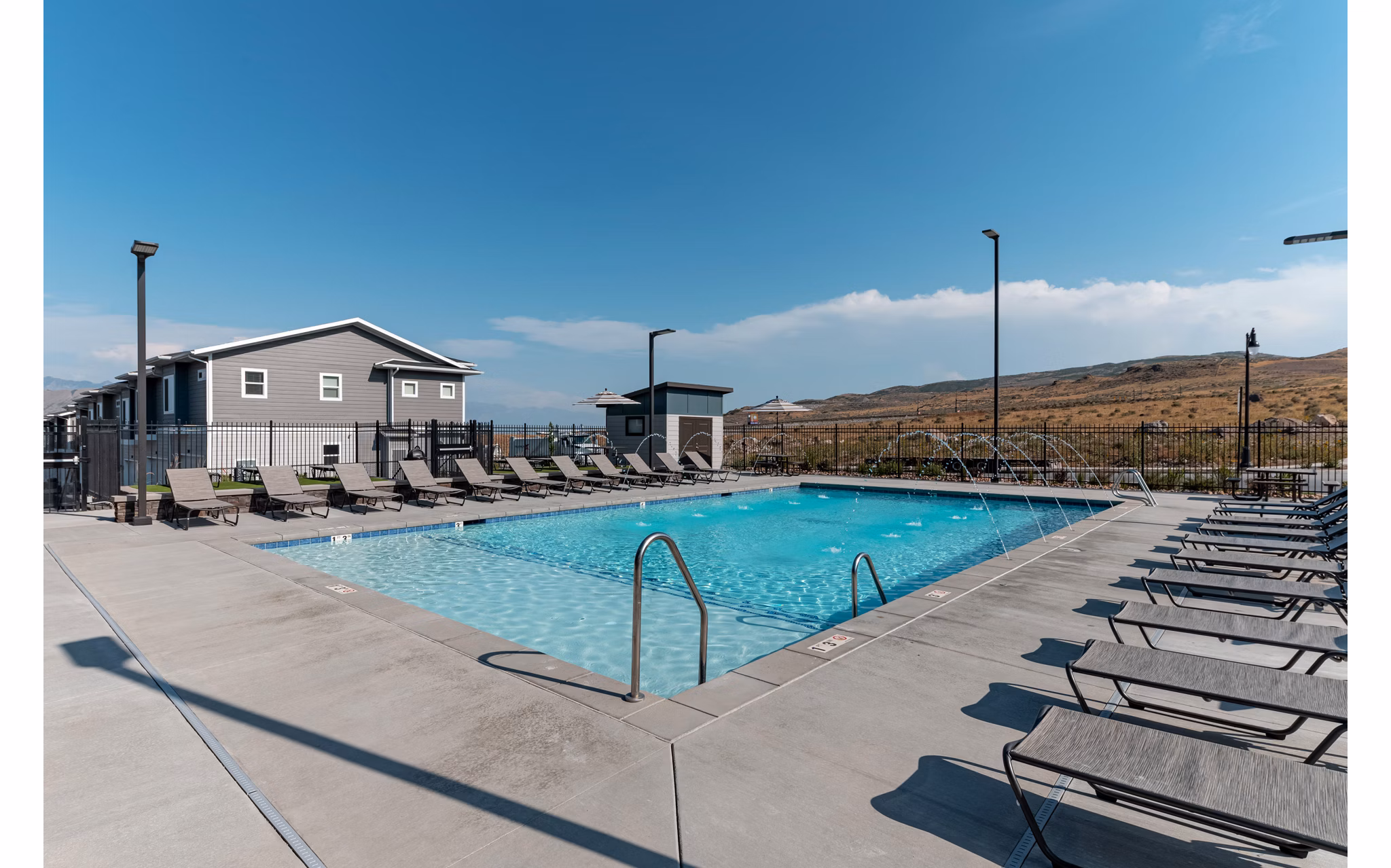 Sun-drenched outdoor pool at Haven Dell Apartments with lounge seating