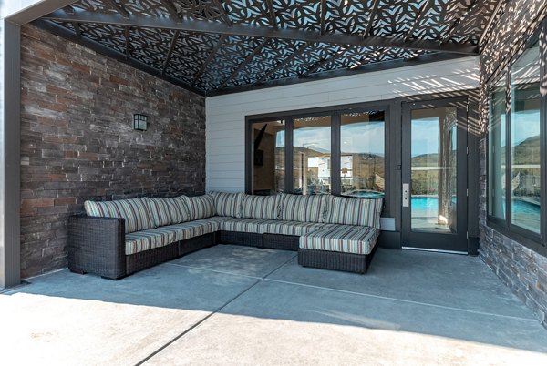Relaxing patio area with comfortable seating and lush greenery at Haven Dell Apartments