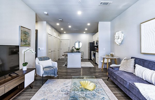 Spacious living room with modern decor at Album Benbrook Apartments, featuring luxurious seating and natural light