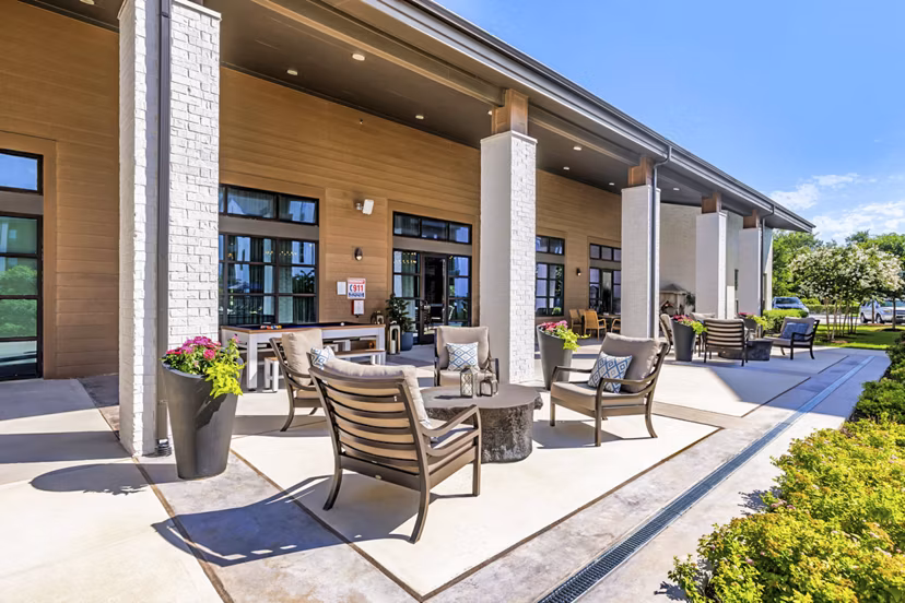Patio area at Album Benbrook Apartments featuring modern outdoor seating and garden views