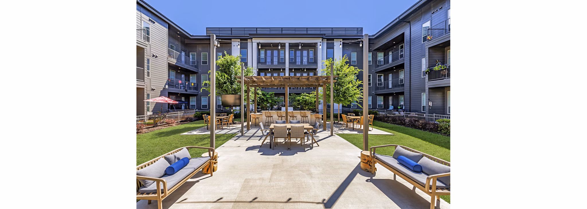 Grill area with seating on patio at Album Benbrook Apartments, offering a luxurious outdoor experience for residents