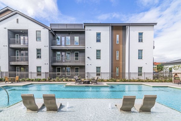 Sparkling outdoor pool at Album Benbrook Apartments offering luxury relaxation and leisure amenities in a vibrant community setting