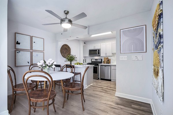 Dining room with elegant wooden furnishings at Potomac Towers Apartments, featuring modern lighting and stylish decor