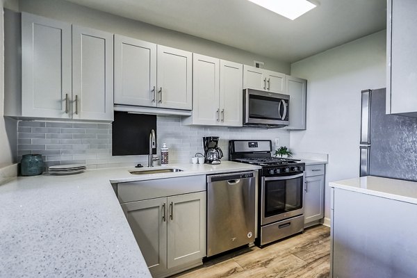 Modern kitchen featuring granite countertops and stainless steel appliances at Potomac Towers Apartments