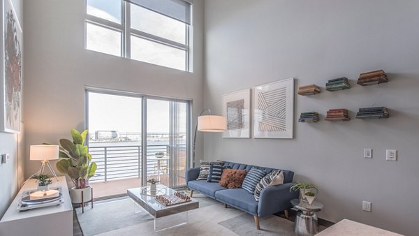 Cozy living room with waterfront view at Boston East Apartments, featuring modern decor and open space design