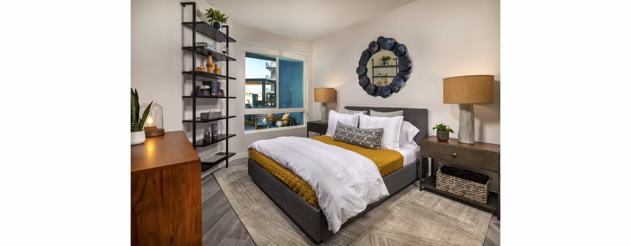 Cozy bedroom with modern decor at Garrison Apartments featuring plush bedding and ample natural light